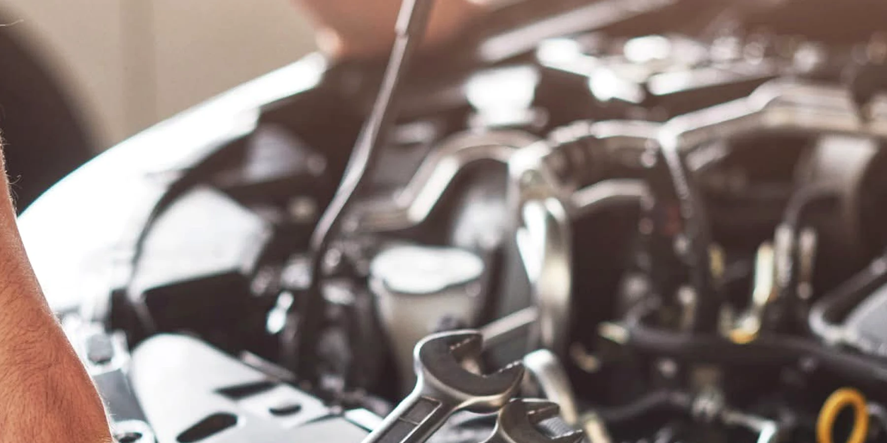 Open-end wrenches staged over an engine bay during repair work