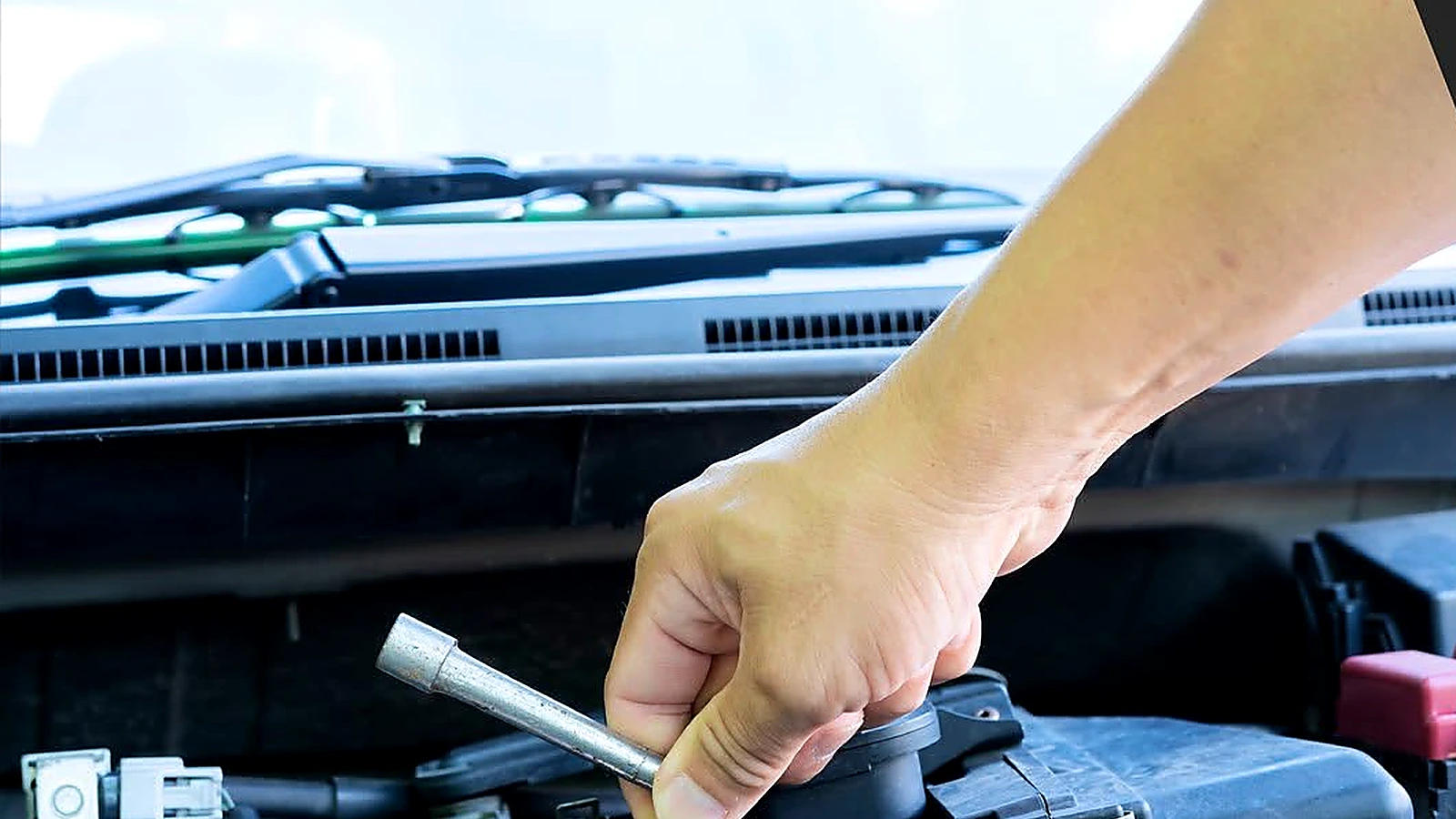 Hands using a wrench during an under-hood repair at 1660 Autocare