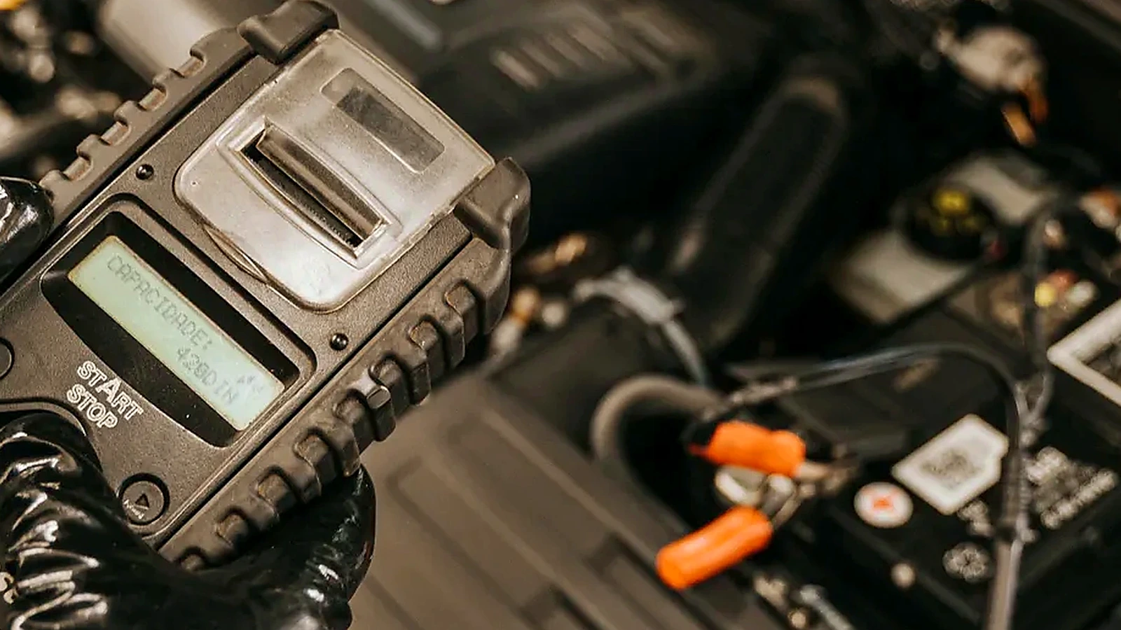 Automotive diagnostic scanner connected under the hood during vehicle testing